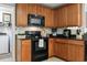 Close up of a kitchen with wooden cabinets, black appliances and light-colored backsplash tiles at 424 Enderby Way, Little River, SC 29566