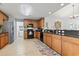 A spacious kitchen featuring tile floors, wooden cabinets, black appliances and dark countertops at 424 Enderby Way, Little River, SC 29566
