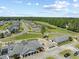 Aerial view of a charming community featuring well-maintained streets, green spaces, and a pond at 439 Colonial Trace Dr. # 119, Longs, SC 29568