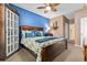 Cozy bedroom with blue accent wall, wooden furniture, carpeted floor and natural light providing comfortable retreat at 439 Colonial Trace Dr. # 119, Longs, SC 29568