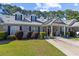 This townhome features covered parking, tidy landscaping, and a welcoming front porch with rocking chairs at 439 Colonial Trace Dr. # 119, Longs, SC 29568
