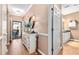 Inviting hallway with hardwood floors, decorative console table, and access to the back patio and a bathroom at 439 Colonial Trace Dr. # 119, Longs, SC 29568