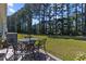 Outdoor patio with chairs, table, and umbrella, offering a relaxing space overlooking the lush yard at 439 Colonial Trace Dr. # 119, Longs, SC 29568