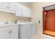 Laundry room featuring a sink, white cabinetry, modern washer and dryer, and an elevator entrance at 4413 Plantation Harbour Dr. # A, Little River, SC 29566