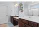 Bathroom boasts dual sinks with dark wood cabinets and a decorative butterfly wall hanging at 4419 Kinlaw St., Little River, SC 29566