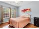Bright bedroom with hardwood floors, large windows, and a light orange quilt at 4419 Kinlaw St., Little River, SC 29566