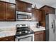 Close up shot of microwave and stove with dark wood cabinets and granite countertops at 4419 Kinlaw St., Little River, SC 29566