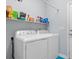 Functional laundry room with a washer, dryer, and storage shelving for supplies at 4419 Kinlaw St., Little River, SC 29566