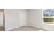 Well-lit bedroom with neutral carpet, white door, and a window looking out at the yard at 442 Acosta Circle, Conway, SC 29527