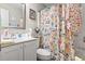 Bathroom with white vanity, flowered shower curtain, and coordinated décor, creating a peaceful retreat at 4497 Little River Inn Ln. # 1502, Little River, SC 29566