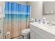 Clean bathroom featuring beach-themed shower curtain, white vanity, toilet, and coordinated decor at 4497 Little River Inn Ln. # 1502, Little River, SC 29566