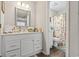 Bathroom vanity with white cabinets and floral shower curtain, offering a bright and inviting space at 4497 Little River Inn Ln. # 1502, Little River, SC 29566