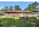 Backyard view of a brick home featuring a deck, green grass, and a fenced in yard at 450 Player St., Georgetown, SC 29440