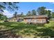 Backyard view of a brick home featuring a deck, green grass, and a fenced in yard at 450 Player St., Georgetown, SC 29440