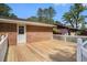 A wooden deck with white railing overlooks the surrounding yard, leading to a door to the home's interior at 450 Player St., Georgetown, SC 29440