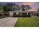 Well-maintained brick home with a neat front yard and mature trees set against a serene sky at sunset, creating a warm ambiance at 450 Player St., Georgetown, SC 29440