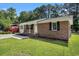 Charming brick home featuring a well-manicured lawn, mature trees, and a welcoming front porch, offering curb appeal at 450 Player St., Georgetown, SC 29440