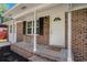 Inviting front porch with brick facade, white columns, and a 'Home Sweet Home' welcome mat at 450 Player St., Georgetown, SC 29440