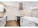 Open kitchen with white cabinets, stainless appliances, quartz countertops, and hardwood floors at 450 Player St., Georgetown, SC 29440