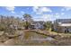 Charming home with a pond view, complemented by lush greenery and nearby buildings under a blue sky at 4616 Eyerly St., North Myrtle Beach, SC 29582