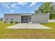 The backyard features a large concrete patio, enclosed screened in porch, and gray siding at 478 Samara Dr., Longs, SC 29568