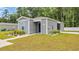 Single-story home with gray siding and a blue front door, complemented by manicured landscaping at 478 Samara Dr., Longs, SC 29568