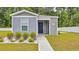 Charming home featuring stylish gray siding, a vibrant blue front door, and meticulously arranged landscaping at 478 Samara Dr., Longs, SC 29568