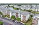Condominium building surrounded by lush landscaping, a peaceful pond, and other residential buildings at 4887 Luster Leaf Circle # 105, Myrtle Beach, SC 29577