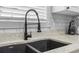 Close-up of black kitchen sink with modern faucet and white subway tile backsplash at 4887 Luster Leaf Circle # 105, Myrtle Beach, SC 29577