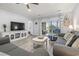 Bright living room features gray sofas, a white TV console, and access to the patio and bedroom at 4887 Luster Leaf Circle # 105, Myrtle Beach, SC 29577