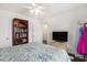 Well lit bedroom with a bed, built-in shelving, hardwood flooring, and a mounted television at 4925 Pond Shoals Ct. # 202, Myrtle Beach, SC 29579