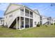 Charming exterior featuring private screened porches, stairs leading to the second level, and lush green lawn at 4925 Pond Shoals Ct. # 202, Myrtle Beach, SC 29579