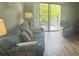 Living room with wood-look flooring, comfortable seating, and a balcony view at 5001 Little River Rd. # E-306, Myrtle Beach, SC 29577