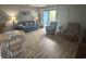 Living room with wood-look flooring, comfortable seating, and a sliding glass door to the balcony at 5001 Little River Rd. # E-306, Myrtle Beach, SC 29577