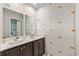 Bathroom with double sinks, decorative wallpaper, and a vanity with dark cabinets at 5068 Wavering Place Loop, Myrtle Beach, SC 29579