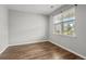 Empty bedroom with hardwood flooring and a large window providing natural light at 5068 Wavering Place Loop, Myrtle Beach, SC 29579