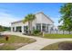 Exterior view of a white clubhouse with a covered entryway, large windows, and lush landscaping at 5068 Wavering Place Loop, Myrtle Beach, SC 29579