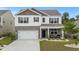 Charming two-story home features a two-car garage, inviting front porch, and well-manicured landscaping at 5068 Wavering Place Loop, Myrtle Beach, SC 29579