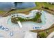 Aerial view of the lazy river pool with palm trees, lounge chairs, and views of the lake and surrounding landscape at 5068 Wavering Place Loop, Myrtle Beach, SC 29579