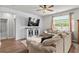 Bright living room with a ceiling fan, large window and a white shiplap accent wall at 5068 Wavering Place Loop, Myrtle Beach, SC 29579