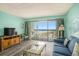 Comfortable living room with a cozy sofa, entertainment center, and balcony access with ocean views at 5511 North Ocean Blvd. # 806, Myrtle Beach, SC 29577