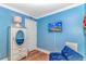 This blue painted bedroom features a stylish dresser and a wall-mounted television at 5905 S Kings Hwy. # 523 A, Myrtle Beach, SC 29575