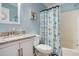 Bright bathroom with a granite vanity, toilet, and shower featuring a nautical-themed curtain at 6000 N Ocean Blvd. # 133, North Myrtle Beach, SC 29582