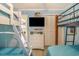 Cheerful bedroom with two bunk beds, light blue walls, a TV, and a white wicker dresser at 6000 N Ocean Blvd. # 133, North Myrtle Beach, SC 29582