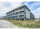 Beachside condo building with multiple balconies and ocean views near grassy dunes at 6000 N Ocean Blvd. # 133, North Myrtle Beach, SC 29582