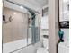 Bathroom featuring a shower with sliding glass doors, a white toilet with cabinet, and a stacked washer dryer at 6001-N73 South Kings Hwy., Myrtle Beach, SC 29575