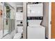 A cozy bathroom with a toilet, cabinet, laundry stack, and updated shower/tub combo at 6001-N73 South Kings Hwy., Myrtle Beach, SC 29575