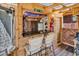 Outdoor bar area with wood paneled walls, granite countertop, bar stools, tv and bbq grill at 6001-N73 South Kings Hwy., Myrtle Beach, SC 29575