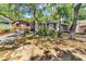 Charming cottage exterior with mature trees, a red door, and dark shutters at 6001-N74 South Kings Hwy., Myrtle Beach, SC 29575
