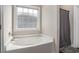 Bathroom featuring a large soaking tub with a shower curtain and frosted window at 630 Heartwood Dr., Conway, SC 29526